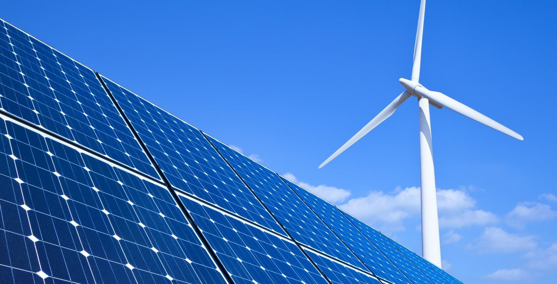 Photovoltaikanlagen mit einer Windkraftanlage im Hintergrund